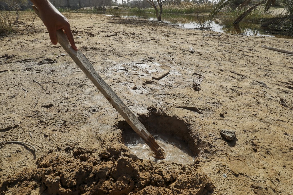 L’eau s’infiltre par un trou dans le sol de la ville de Zliten en raison de la montée des eaux souterraines, le 13 février (Mahmoud Turkia/AFP)