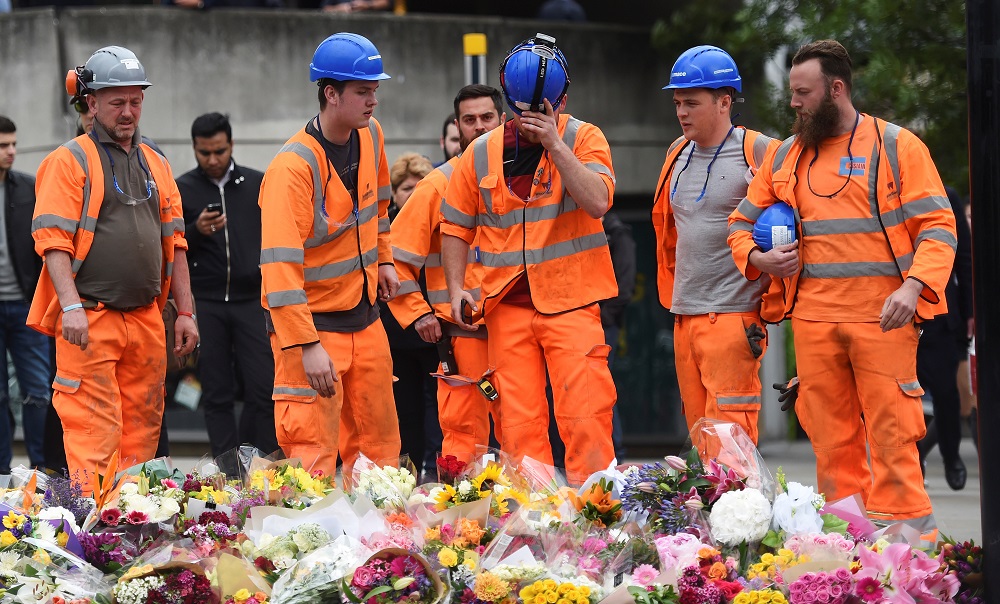 Des ouvriers du bâtiment déposent des fleurs près du lieu de l’attentat du London Bridge, en juin 2017 (Reuters)