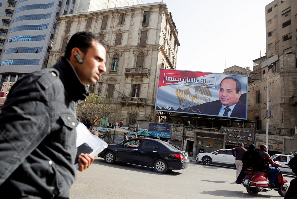 A man walks past a poster featuring President Abdel Fattah al-Sisi in Cairo (Reuters)