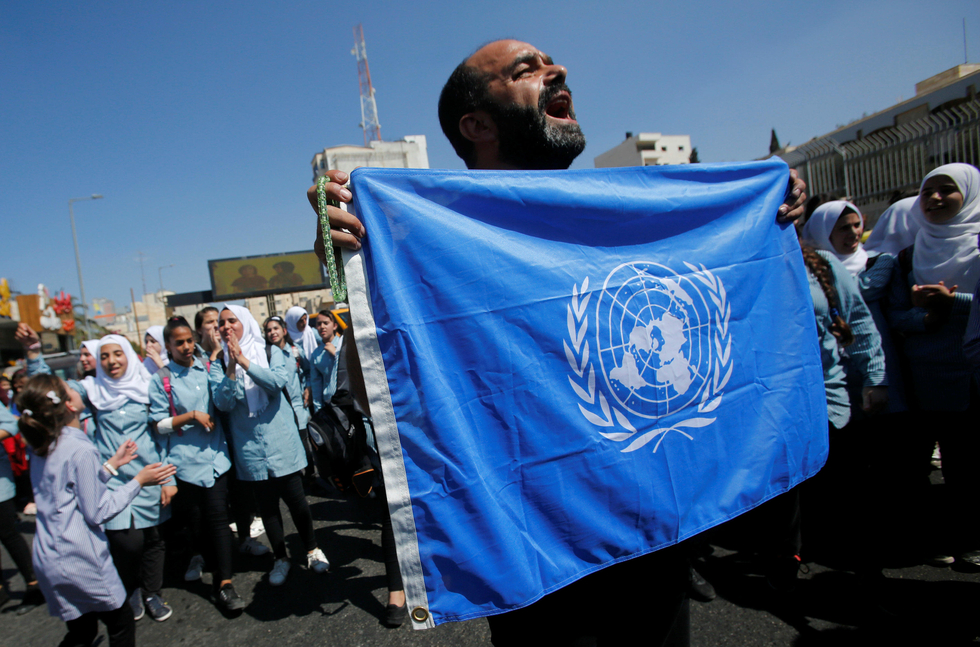 Palestinian demonstrator holds UN flag during a rally against a U.S. decision to cut funding to UNRWA