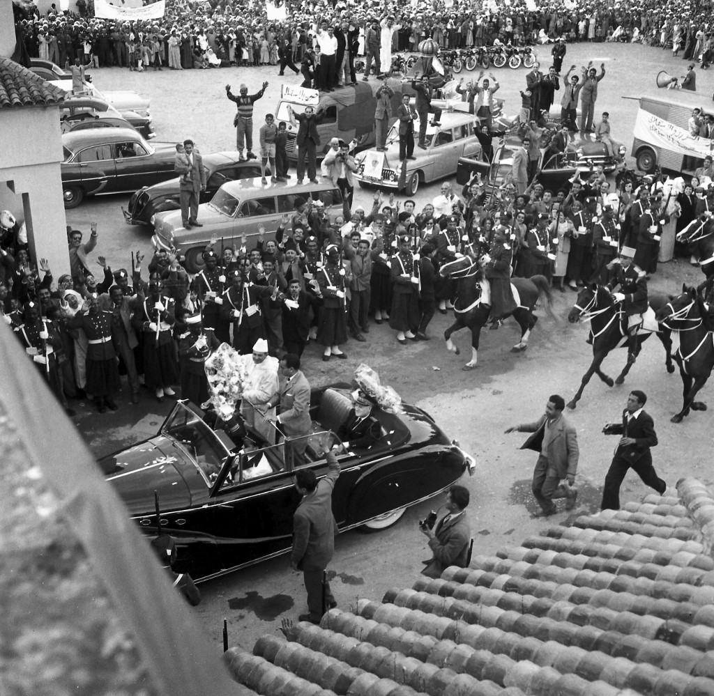Le sultan du Maroc Mohammed V entre au palais royal, avec son fils le prince héritier Moulay Hassan, accueilli par une foule enthousiaste, à Rabat le 6 mars 1956 après son retour de Paris où il a présidé la première phase des négociations franco-françaises (AFP)