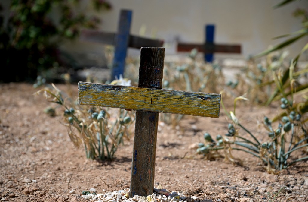 Wooden crosses made with the remains of boats used by migrants to cross the Mediterranean sea are seen in the cemetry where victims of shipwrecks are buried, on the island of Lampedusa, on 25 September 2023.