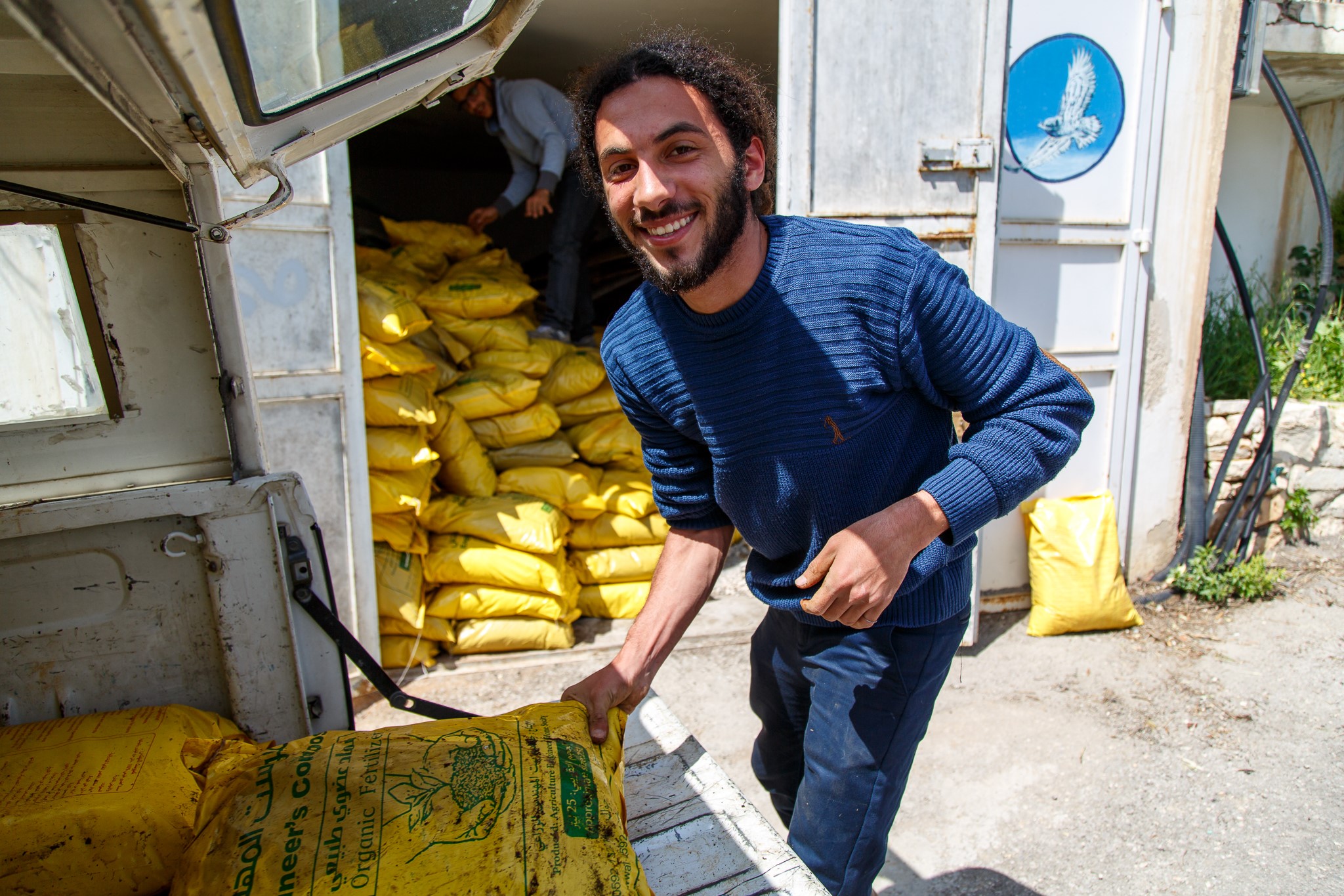 Co-ordinator of the cultural heritage centre at the Museum, Mohammad Najajrah helps to move the compost