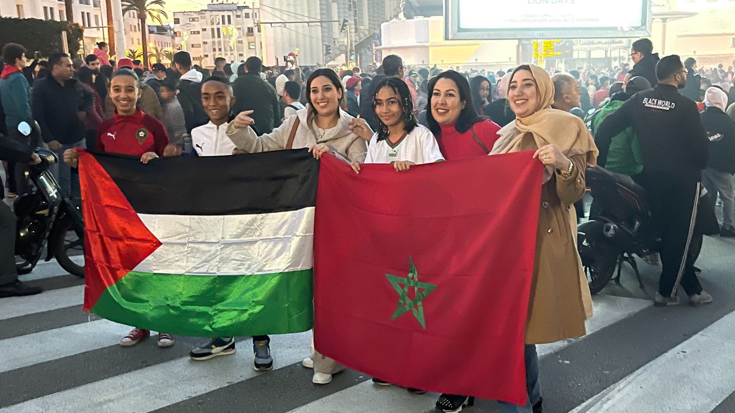 Moroccan fans celebrates their team's win at the Qatar World Cup in Rabat on 10 December 2022 by holding the Moroccan and Palestinian flag (MEE/Austin Bodetti)