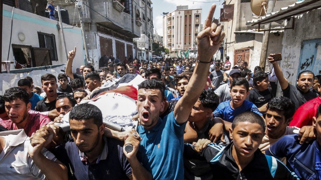 Mourners carry the body of an 11-year-old Palestinian boy who died during protests at his funeral in the Rafah refugee camp, in the southern Gaza Strip, on 28 July 2018 (AFP)