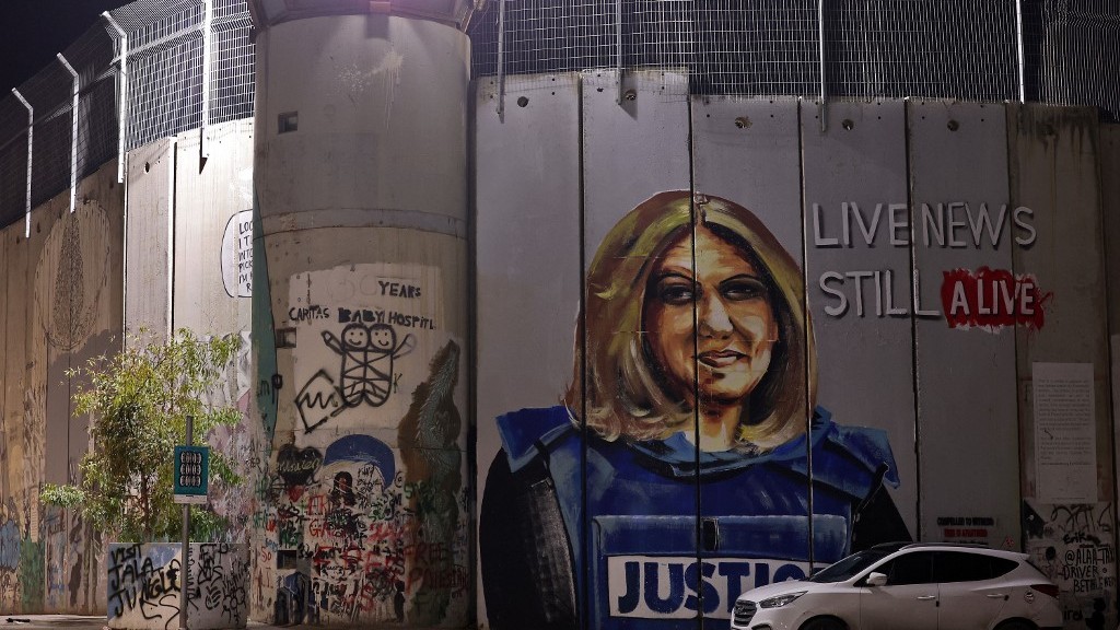 A mural of slain Palestinian American journalist Shireen Abu Akleh is seen on a section of Israel’s separation wall between Jerusalem and Bethlehem on 6 December 2022 (AFP)