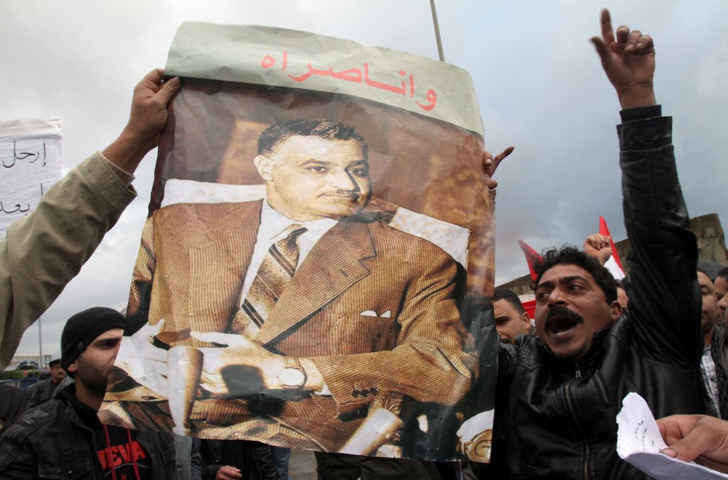 An Egyptian man hoists a poster of Nasser during a protest in Beirut in 2011 (AFP)