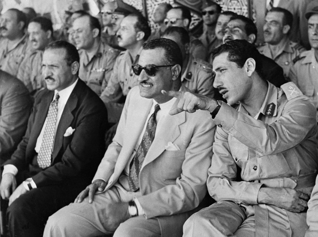 L’ancien président égyptien Gamal Abdel Nasser assis entre le ministre des Affaires locales et le chef de l’armée en 1956 (AFP)