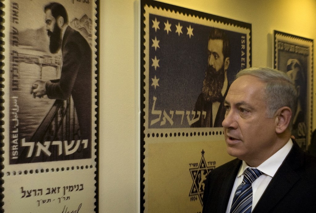 Israeli Prime Minister Benjamin Netanyahu looks at posters of stamps featuring Zionism founder Theodor Herzl in Jerusalem in 2010 (AFP)