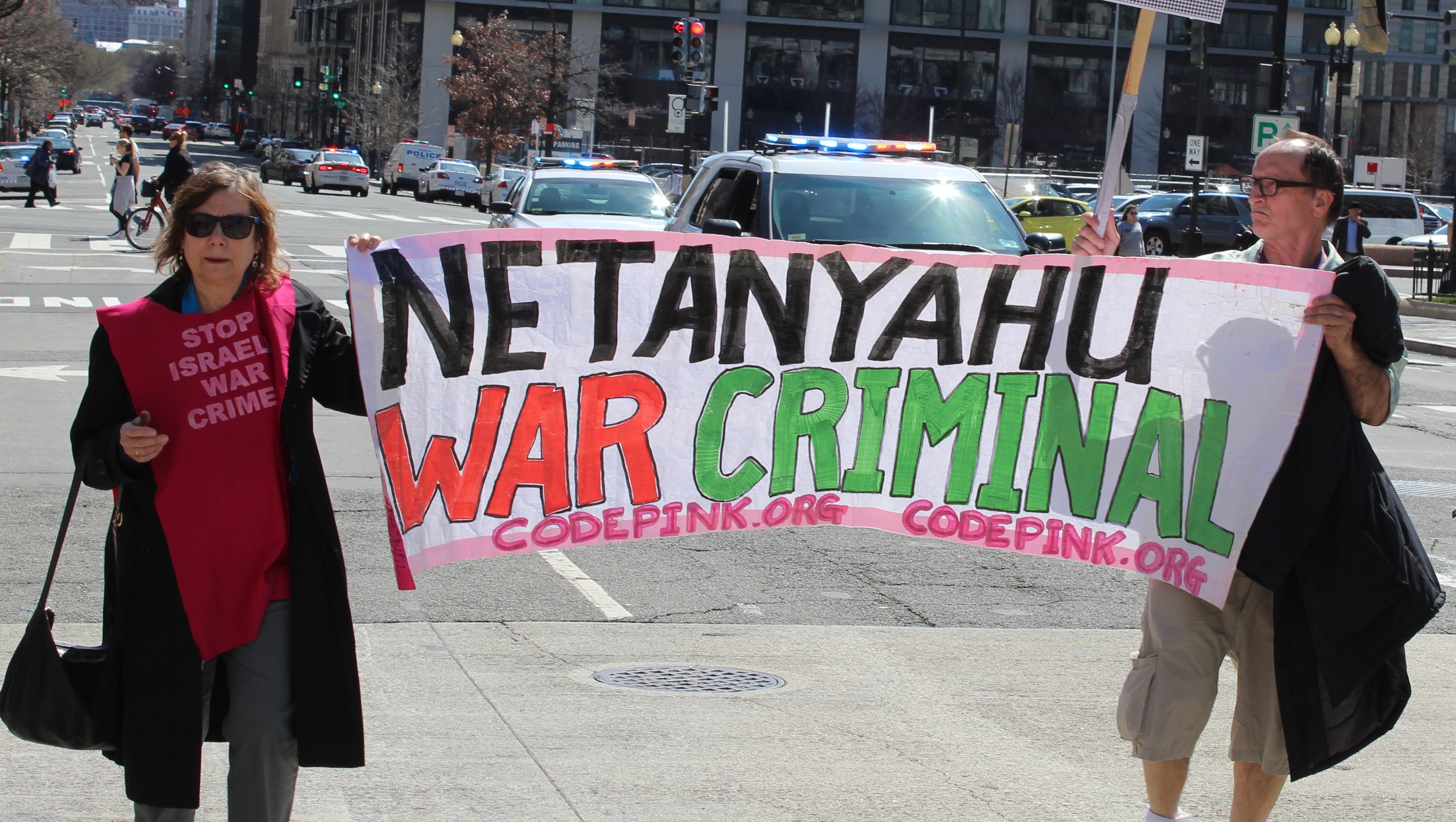 Protesters hold sign outside AIPAC conference (MEE/Ali Harb)