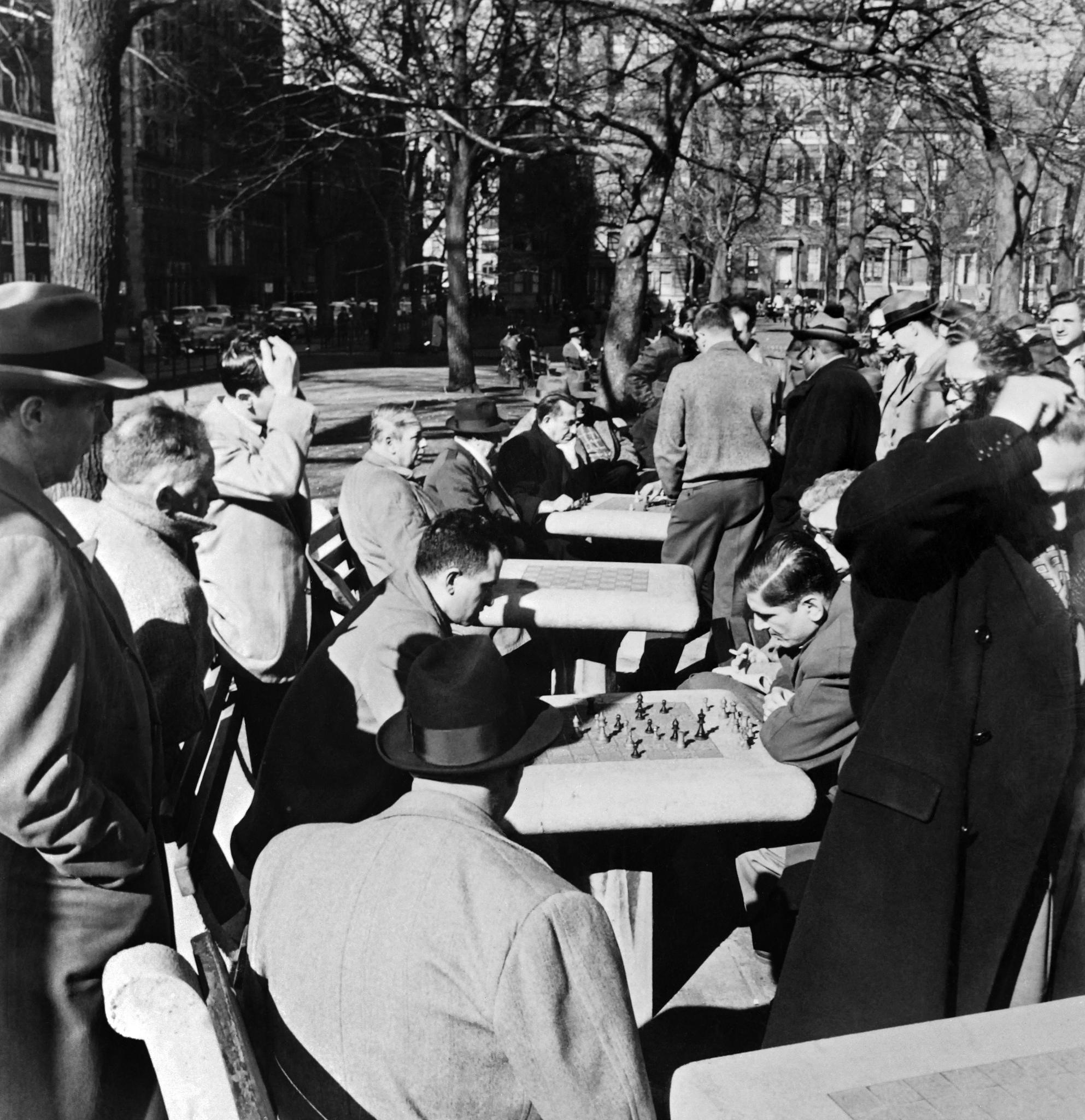 Men playing outdoor chess on stone chess tables in Greenwich Village Park, in the heart of New York in the 1960s (AFP) 
