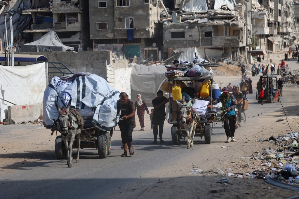 Palestinians transport their belongings as they flee areas north of Gaza City in the northern Gaza Strip on October 12, 2024.