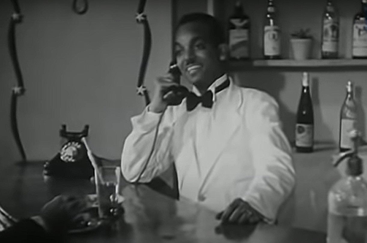 Un figurant nubien anonyme joue le rôle d’un barman dans Une balle au cœur (Rossassa fil-qalb, 1944) (capture d’écran)