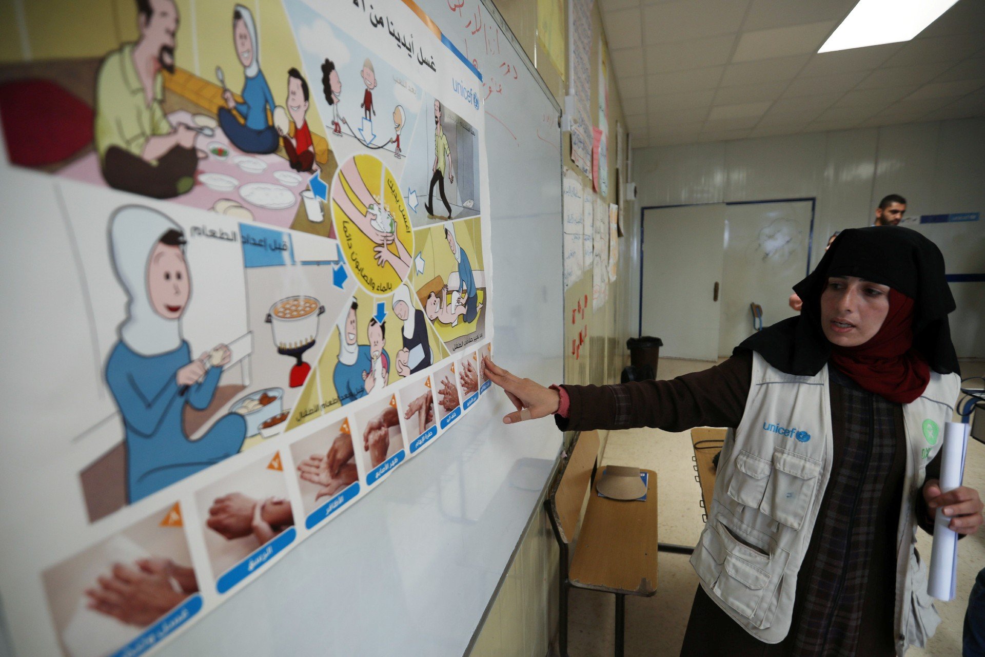 Une salariée d’Oxfam enseigne à des élèves syriens comment se laver les mains dans le cadre d’une campagne de sensibilisation, dans le camp de réfugiés jordanien de Zaatari (Reuters)