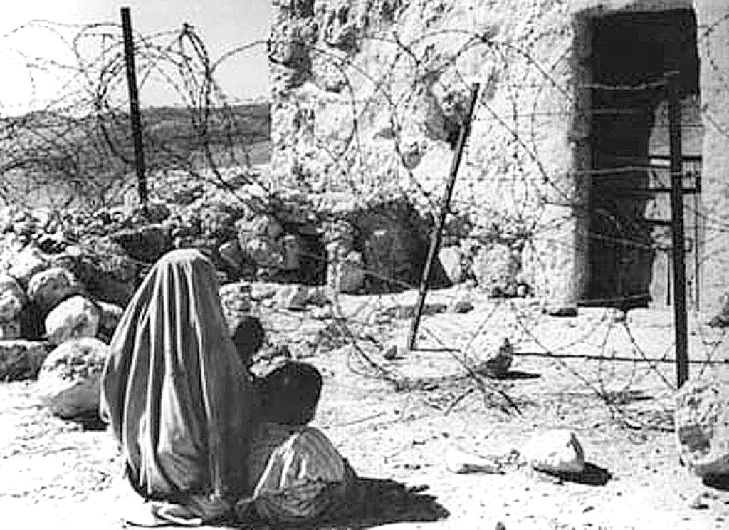 A Palestinian refugee and her child are separated from their home after the 1948 war (AFP)