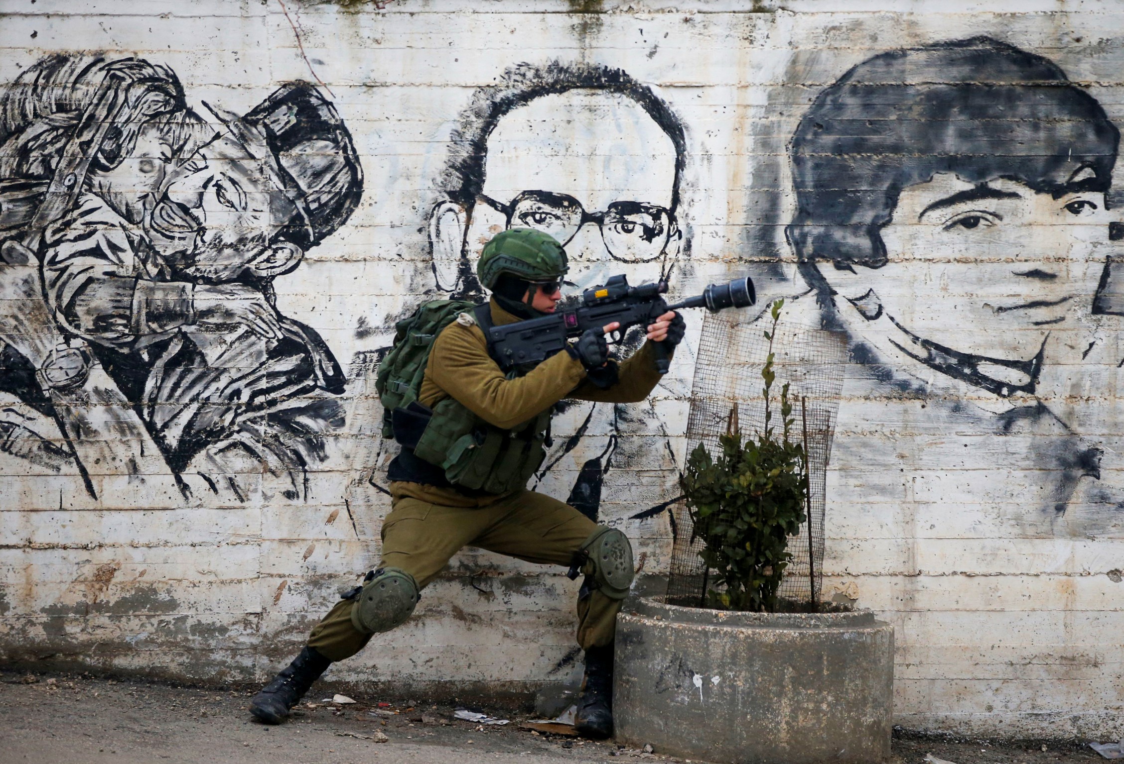 An Israeli soldier fires teargas towards Palestinian demonstrators during a demonstration in al-Aroub Palestinian refugee camp, between the West Bank towns of Hebron and Bethlehem, on January 29, 2020