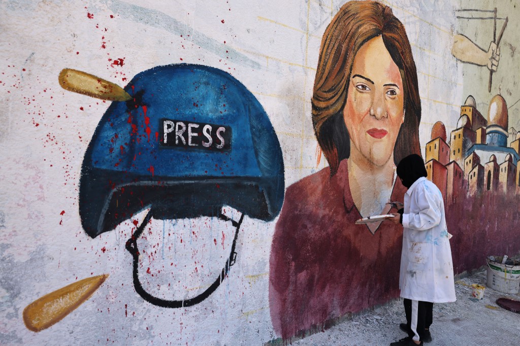 Palestinian artists paint a mural in honour of slain Al Jazeera journalist Shireen Abu Akleh in Gaza City on 12 May 2022 (AFP)