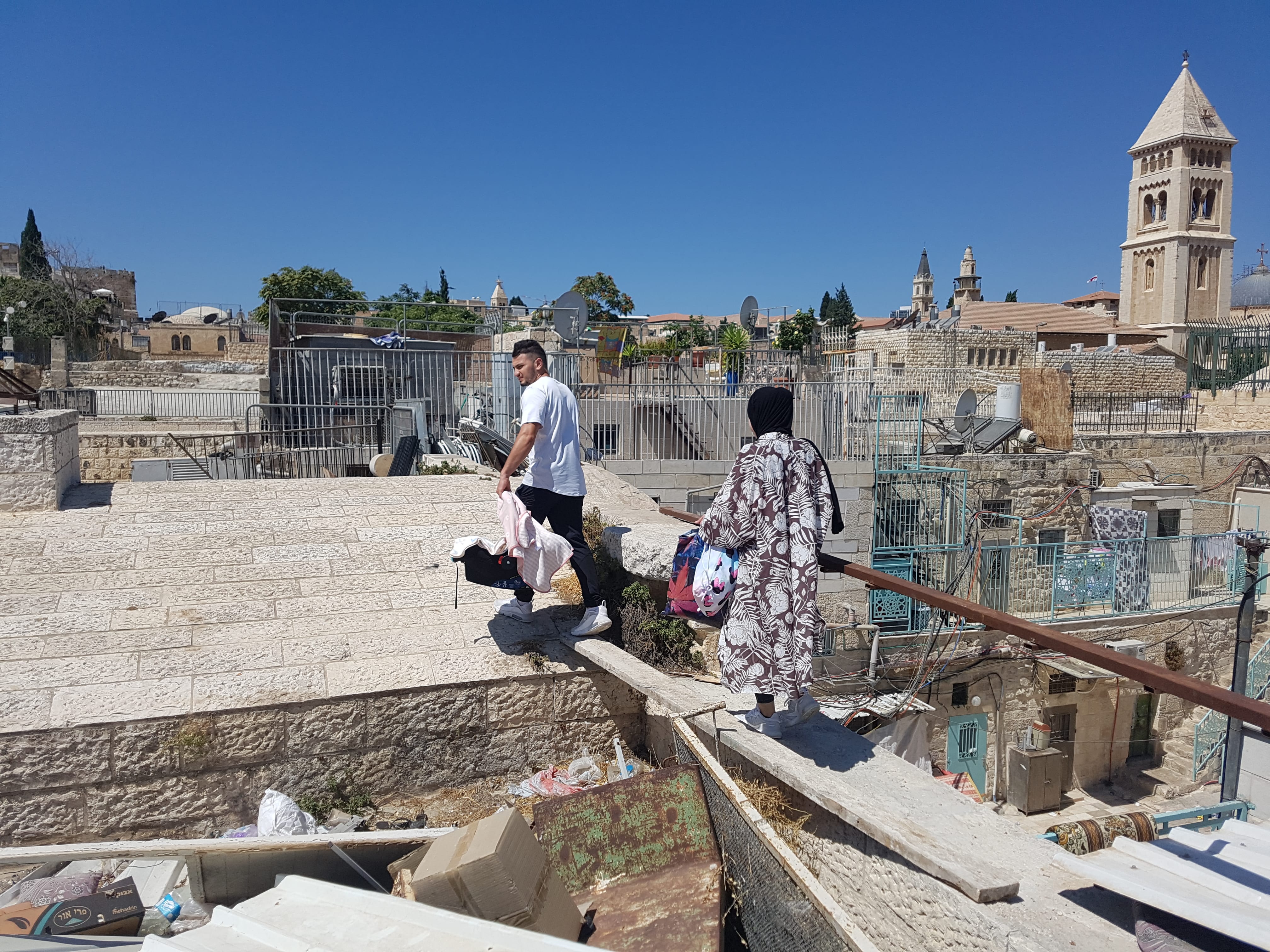 Palestinian family crossing rooftops to leave their neighbourhood in Jerusalem