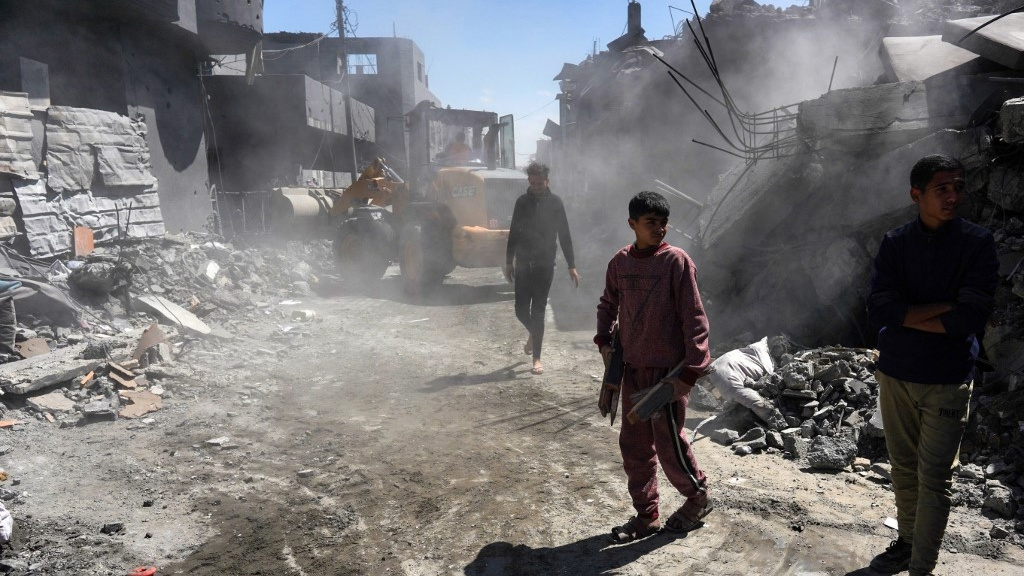 Palestinians clear rubble after an Israeli bombardment in Gaza’s Nuseirat refugee camp on 20 March 2024 (AFP)