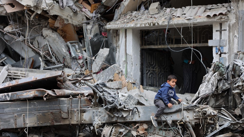 A Palestinian child plays on the ruins of a building destroyed by an Israeli bombardment in Gaza City on 8 April 2024 (AFP)