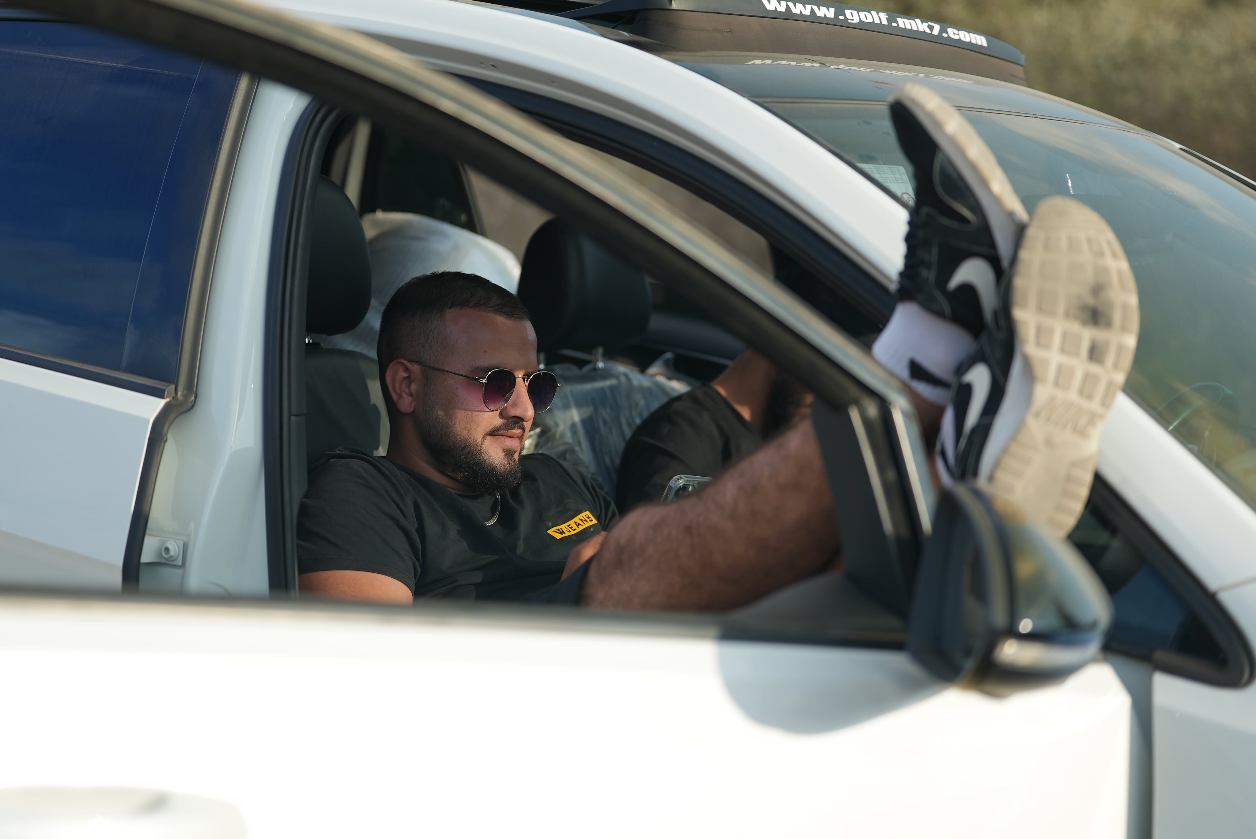 Un Palestinien met les pieds en l’air dans sa voiture alors qu’il patiente avec des centaines d’autres voitures pour franchir le poste de contrôle de Naplouse, le 18 octobre 2022 (MEE/Akram al-Waara)