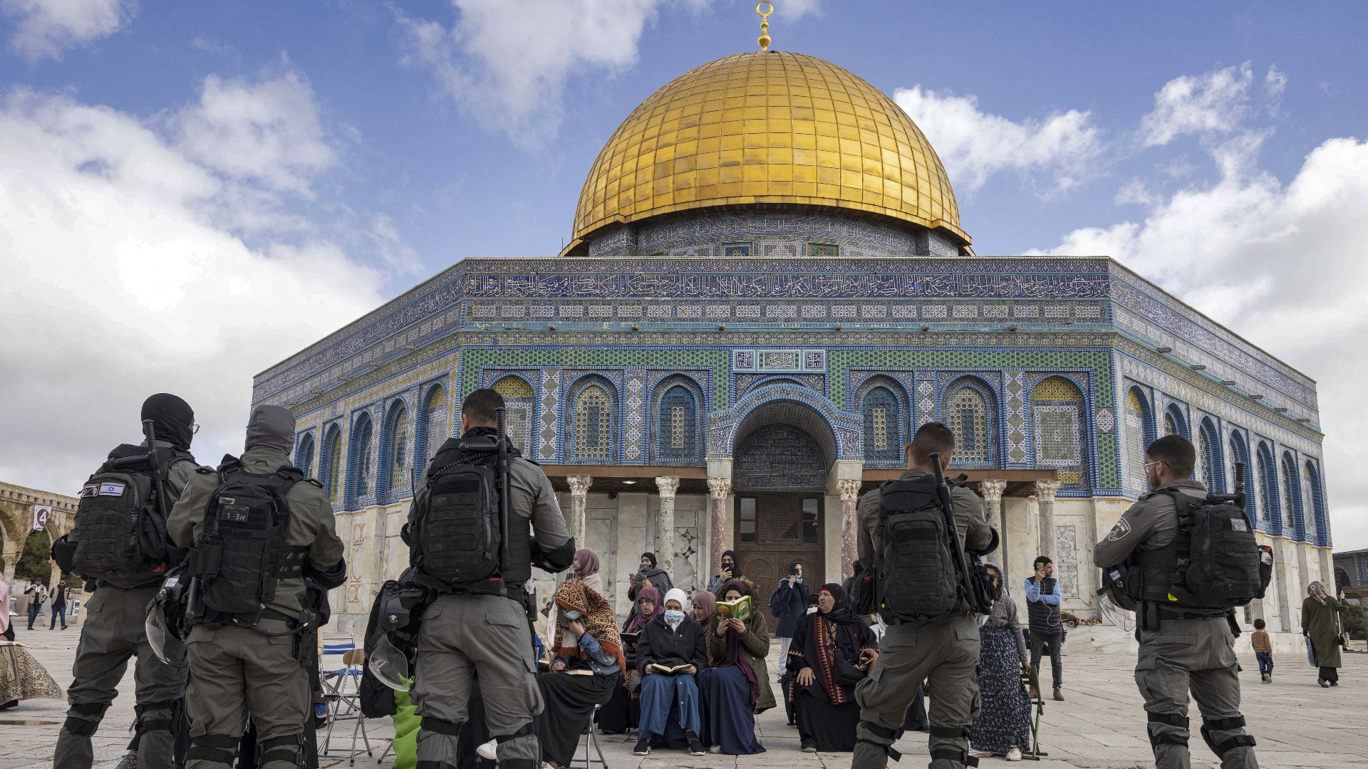 Israeli policemen stand in front of Muslim women praying in front of the Dome of the Rock mosque in the old city of Jerusalem on 20 April, 2022