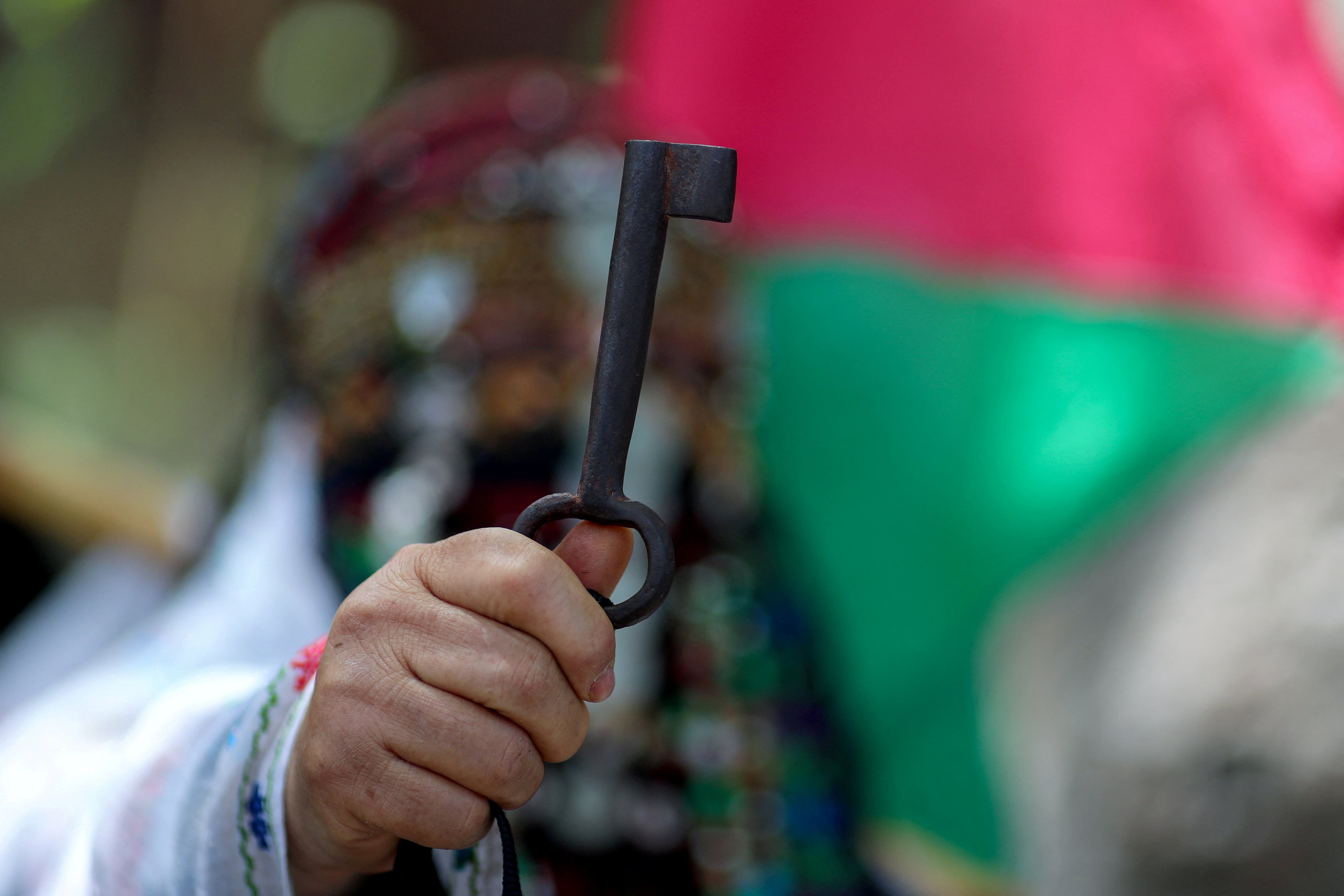 A Palestinian woman in Gaza holds up a key symbolising the right of return on the 74th anniversary of the Nakba (Reuters)