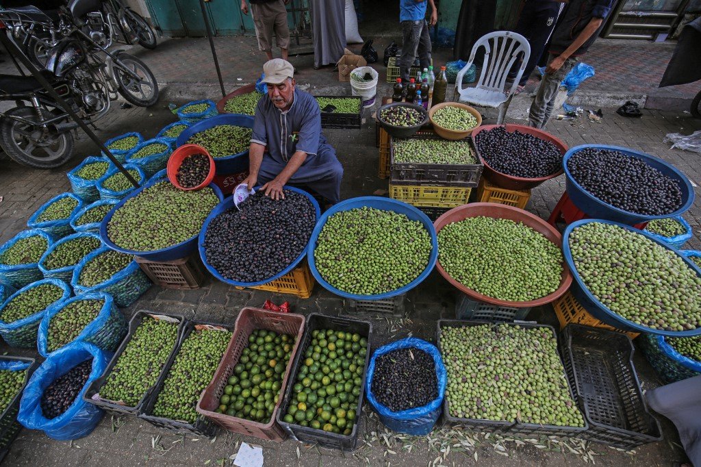 Un palestinien vend des olives sur un marché pendant la saison des récoltes à Khan Younès, dans le sud de la bande de Gaza (AFP)