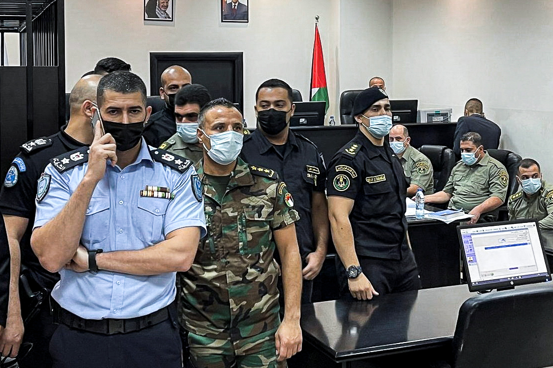 Palestinian security officers stand guard during a trial of security officers (not seen) over the death of Nizar Banat, in Ramallah in the Israeli-occupied West Bank on 14 September 2021. (Reuters)