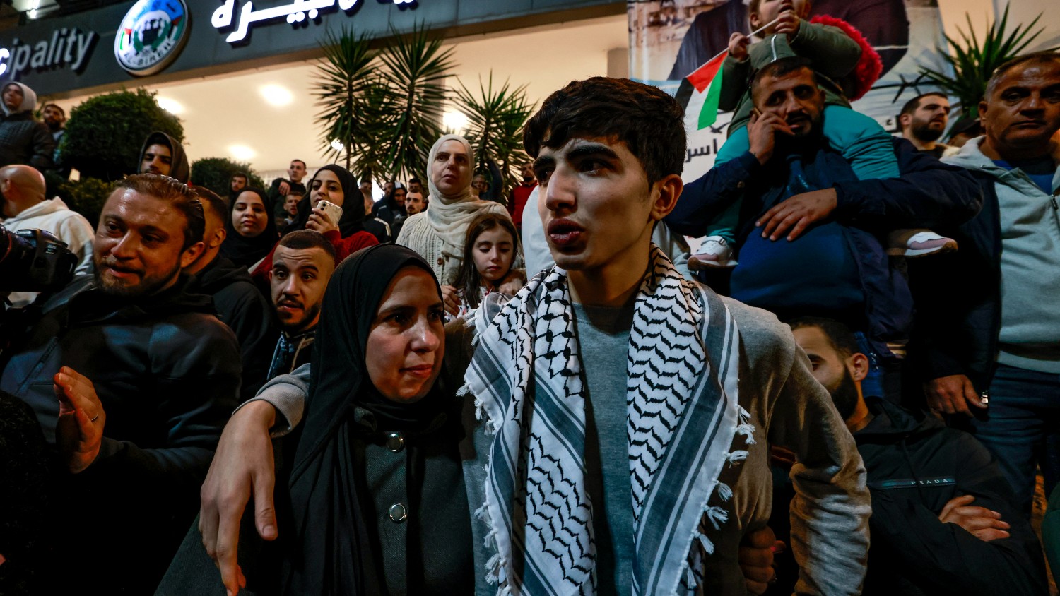 A Palestinian prisoner (R) hugs a relative after detainees were released from Israeli jails in exchange for captives released by Hamas, upon arrival in Ramallah on 26 November 2023.