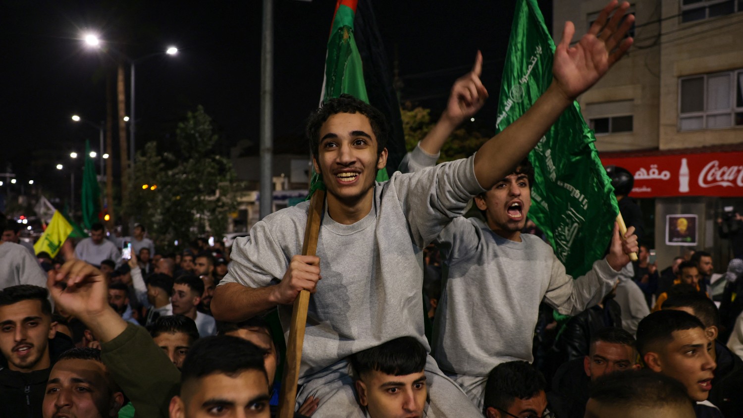 Palestinians prisoners released from Israeli jails cheer among supporters in Ramallah in the occupied West Bank early on 26 November 2023.