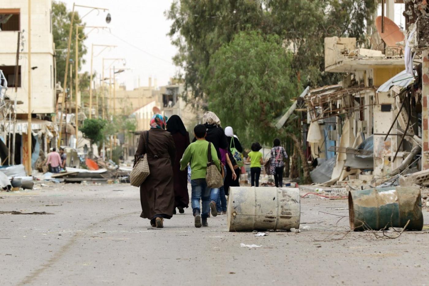 Des Syriens déplacés par les combats retournent dans la ville moderne de Palmyre, adjacente à l’ancienne cité antique, le 9 avril 2016 (AFP)