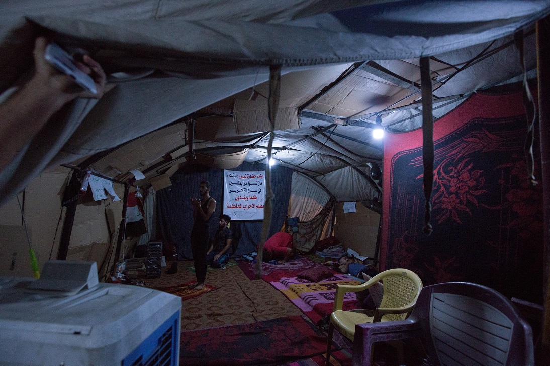 Des manifestants irakiens effectuent les prières nocturnes du tarawih après la rupture du jeûne, dans une tente de la rue Saadoun (MEE-Sarah-Samya Anfis)
