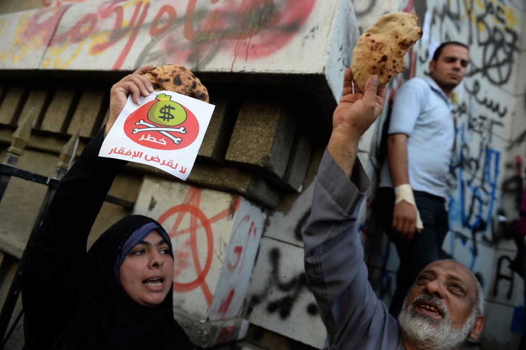  During protests in Cairo against the IMF in 2013, a demonstrator holds a sign that says ‘Danger, no to loans that lead to poverty’