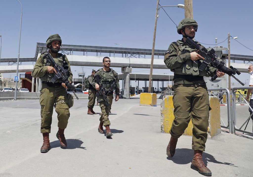 Israeli soldiers gather at Qalandiya checkpoint in the occupied West Bank on 12 May (AFP)