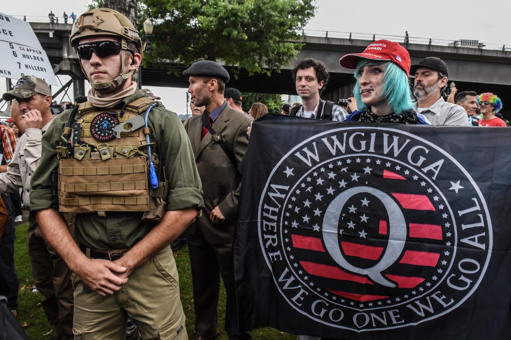 A person holds a banner referencing the QAnon conspiracy theory during an alt-right rally in Portland, Oregon, in August 2019 (AFP)