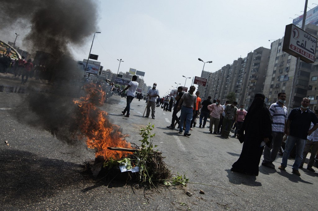 A fire burns near Cairo’s Rabaa Square as riot police move in on protesters in 2013 (AFP)