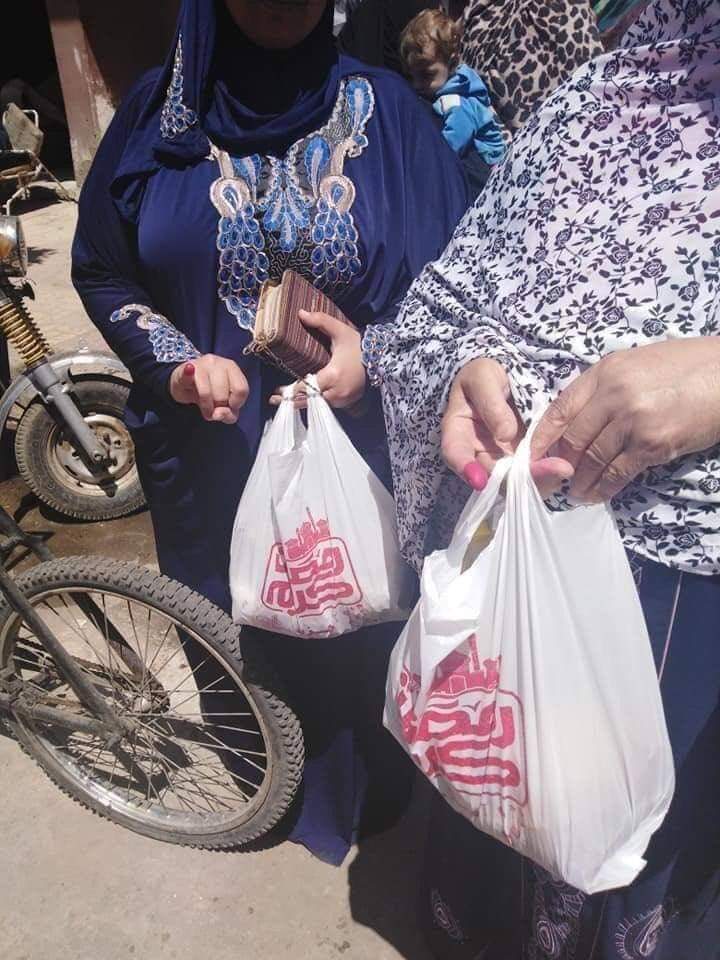 Egyptian women carry their food parcels after voting in the referendum in Cairo (MEE)