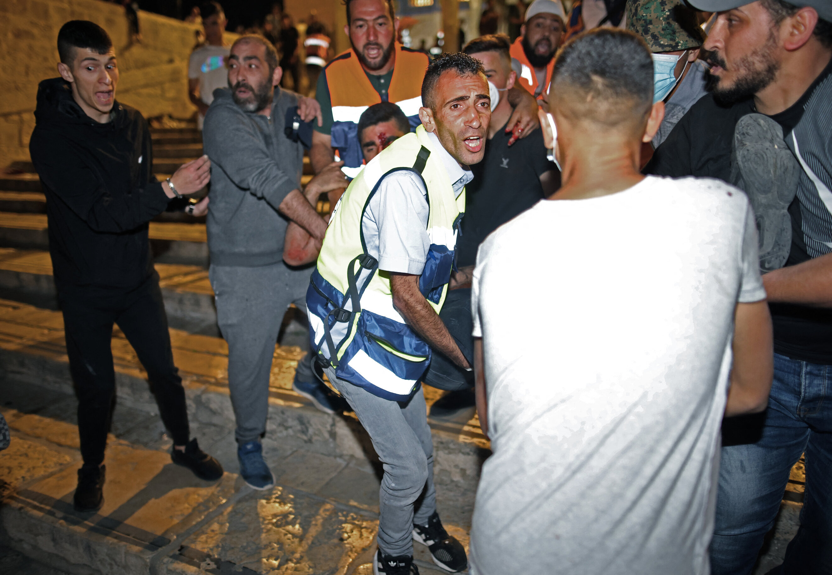 An injured man is carried away as Israeli security forces crackdown on Palestinians at al-Aqsa mosque in Jerusalem on 7 May 2021 (AFP)