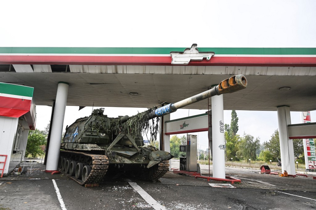 An abandoned Russian tank sits at a gas station in Ukraine’s Kharkiv region on 16 September 2022 (AFP)