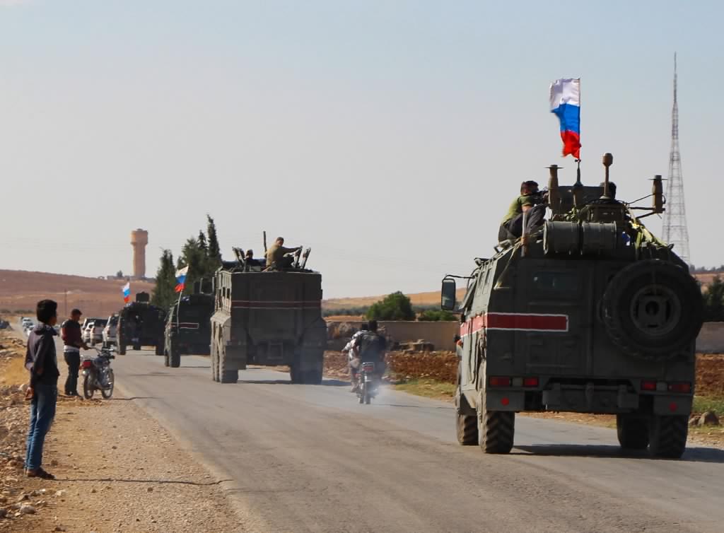 Russian military vehicles drive towards Kobane, Syria, on 23 October (AFP)