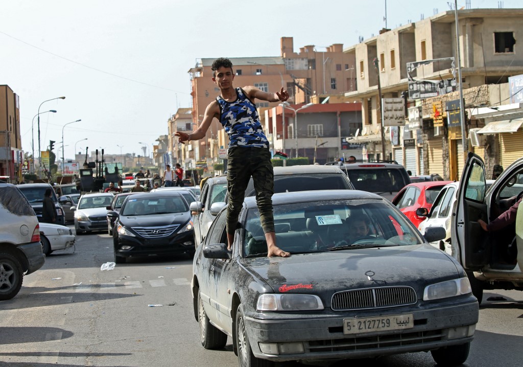 A Libyan man gestures in celebrates as fighter loyal to the UN-recognised Government of National Accord (GNA) drove into the coastal city of Sabratha on April 13, 2020,