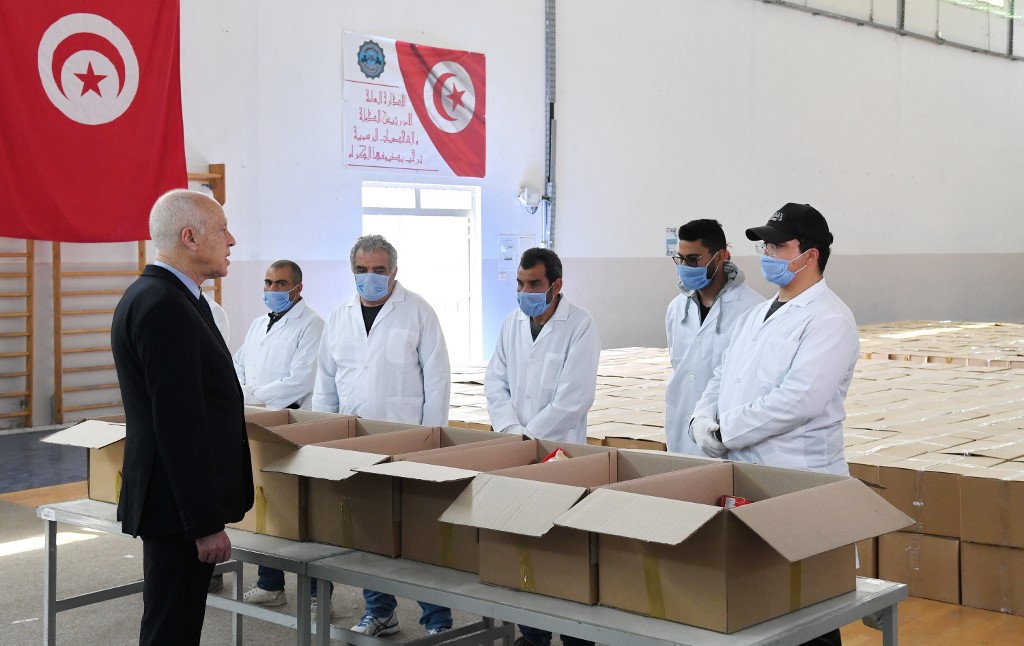 Tunisian President Kais Saied takes part in the distribution of aid packages in Gammarth on 5 April (Tunisian Presidency/AFP)