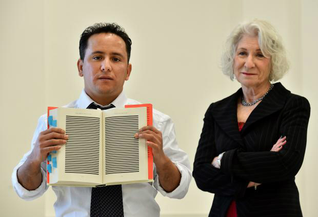 Yahdih Ould Salahi poses with a redacted copy of Mohamedou Salahi's, his older brother, memoirs (AFP)