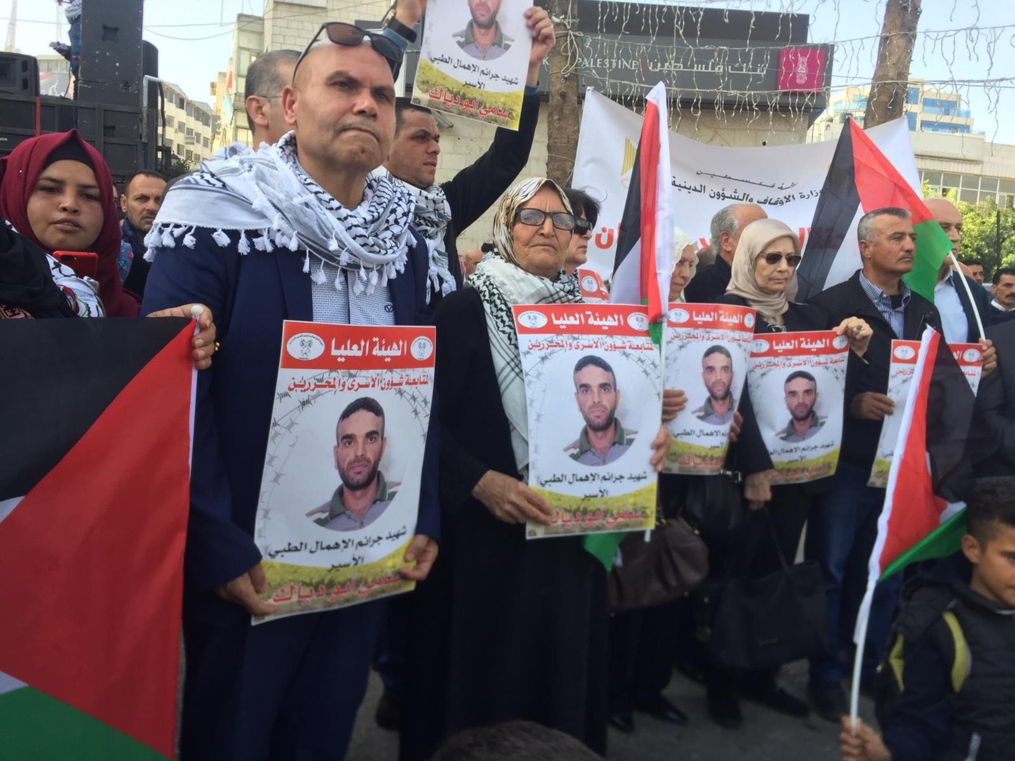 Demonstrators hold photographs of Sami Abu Diyak in Ramallah on 26 November (MEE/Shatha Hammad)