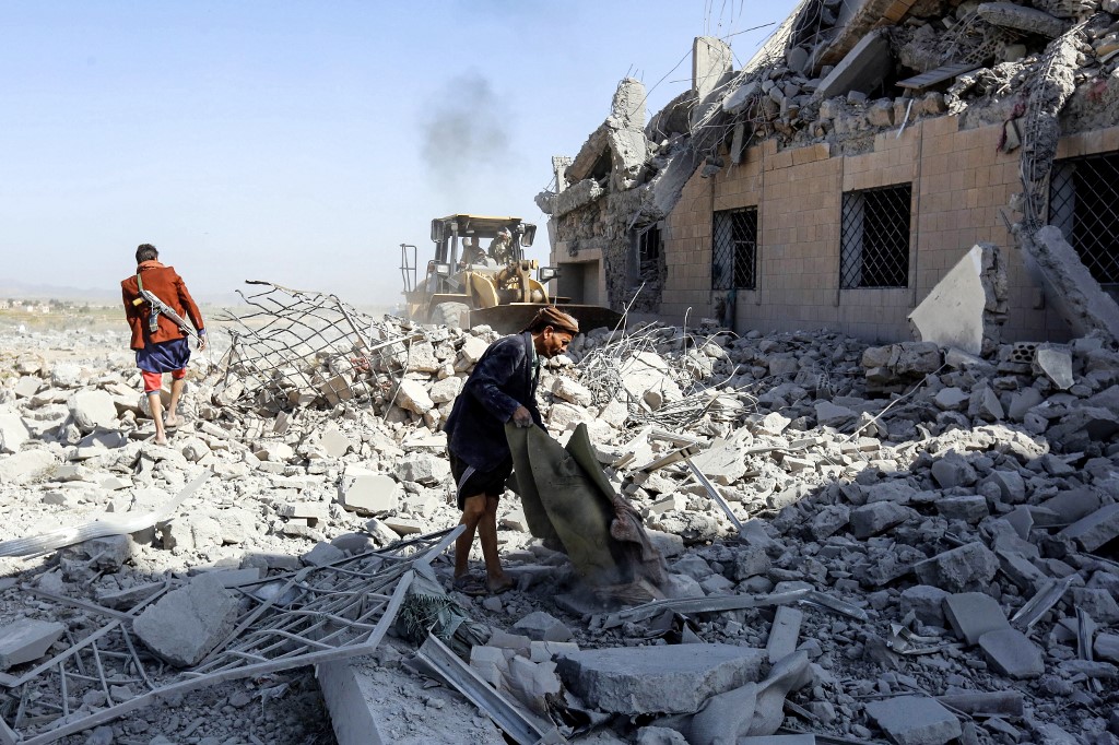 People inspect a destroyed Houthi detention centre south of Sanaa on 1 September (AFP)