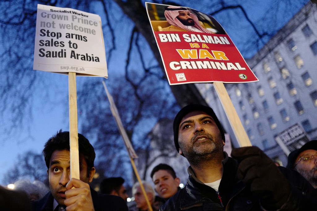Protesters hold up placards as they demonstrate against UK arms sales to Saudi Arabia during the visit of Saudi Arabia's Crown Prince Mohammed bin Salman, outside Downing Street, in central London on March 7, 2018