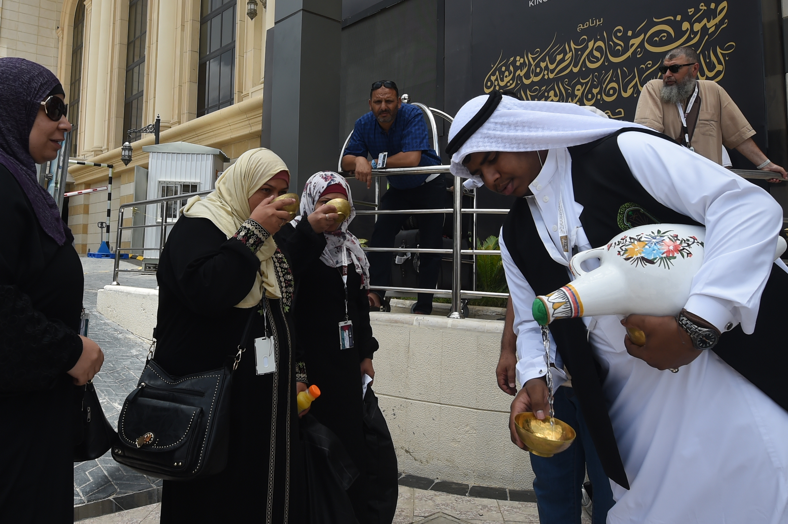 Des Saoudiens offrent aux pèlerins musulmans de l’eau de Zamzam à leur arrivée dans la ville sainte de La Mecque avant le pèlerinage annuel du hadj (AFP)