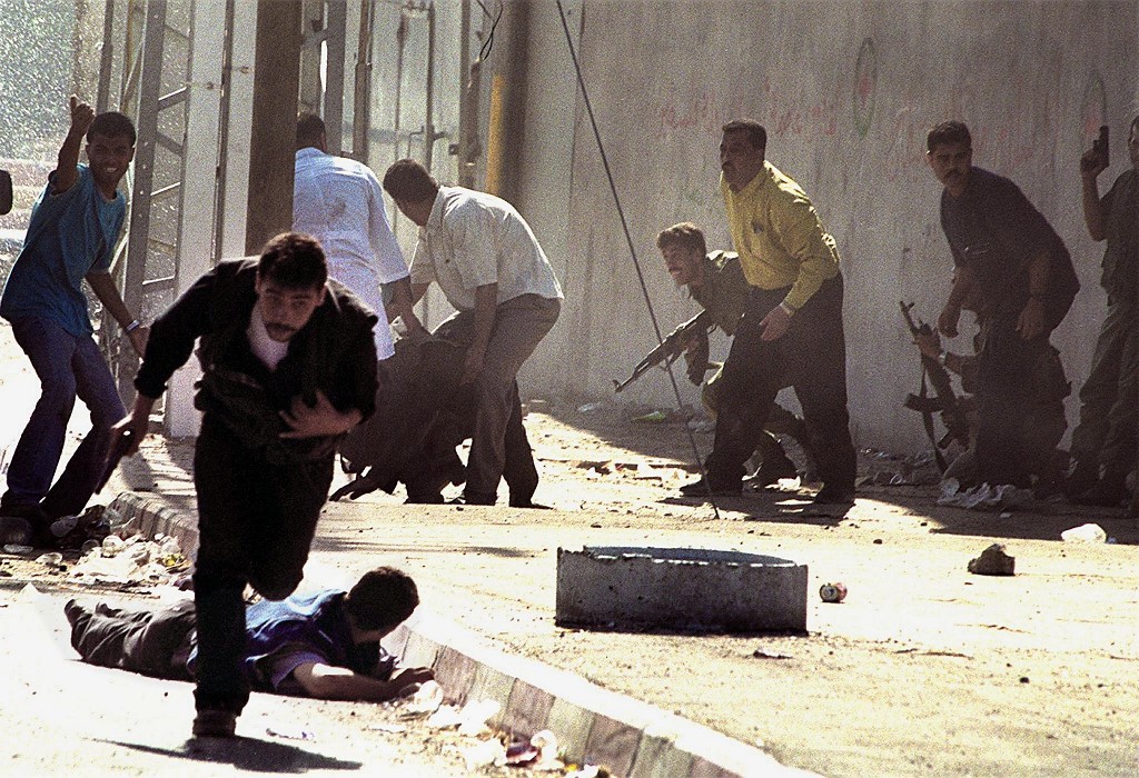 Palestinian police duck as Israeli troops open fire near Gaza City in October 2000 (AFP)