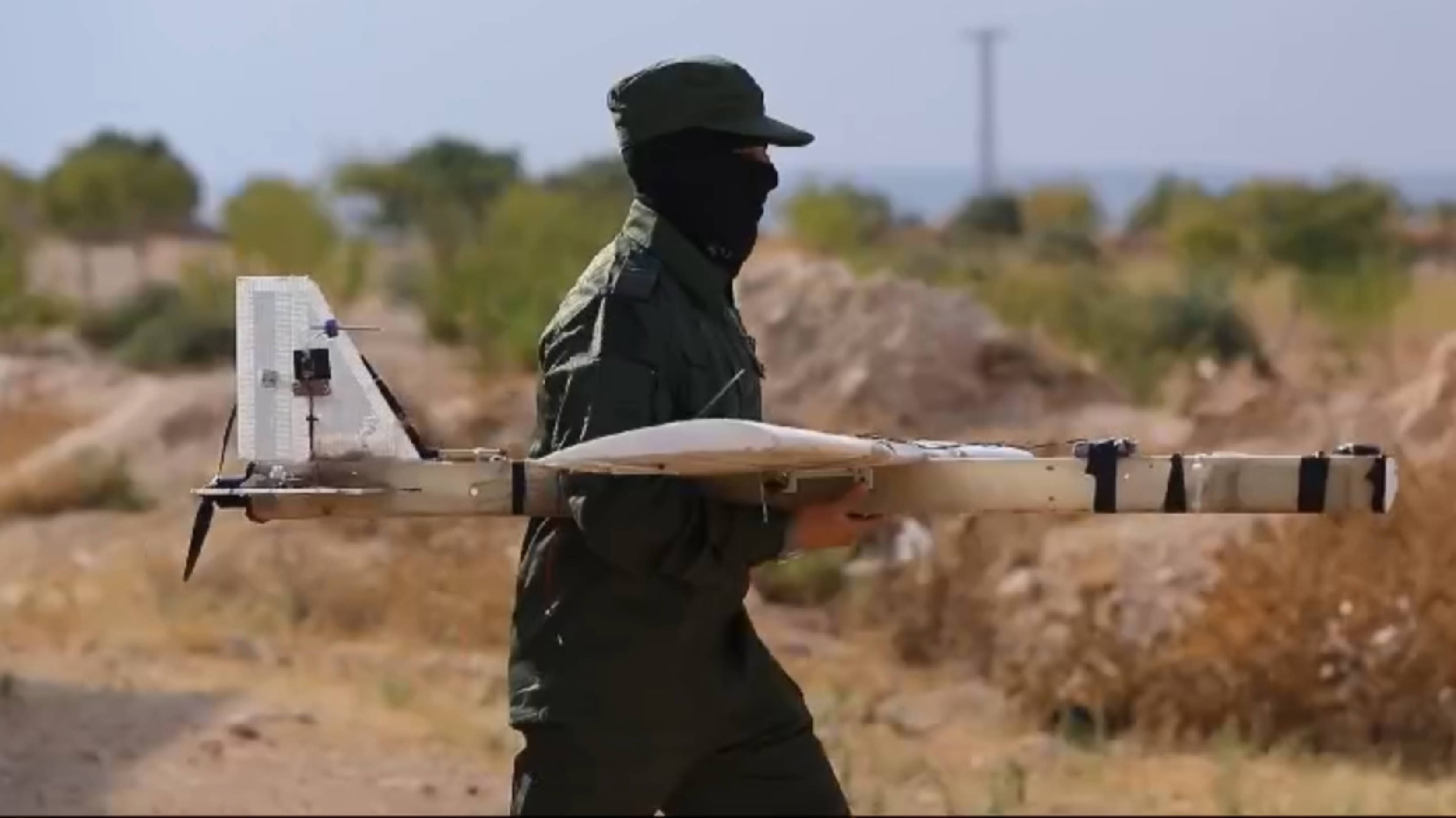 A screenshot from a video published by Hay'at Tahrir al-Sham shows a rebel fighter carrying a suicide drone called (MEE)